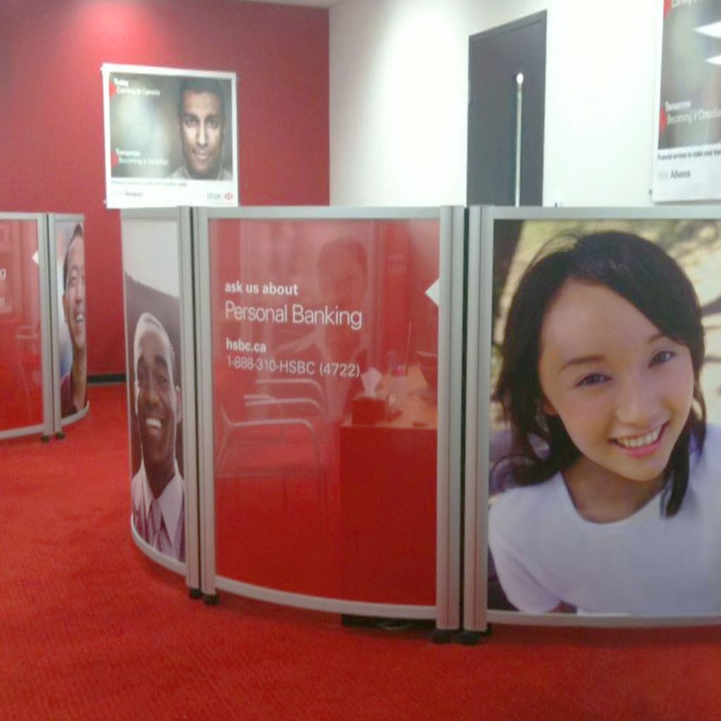 a red and white sign with images of people on it on a curved workstation