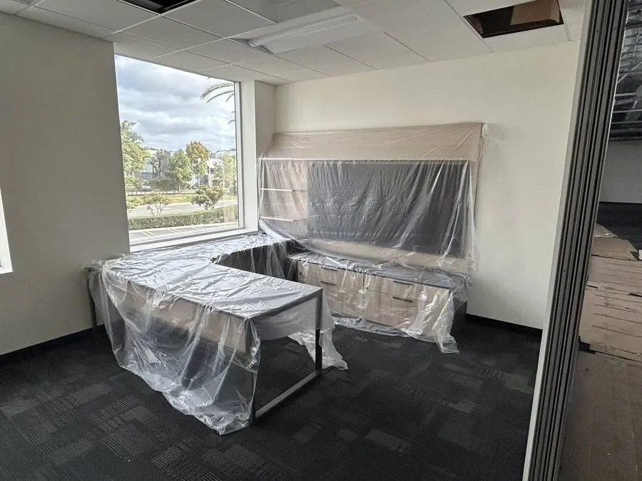 Private office furniture carefully wrapped and protected from dust and construction activity during the phased installation: every piece preserved in perfect condition until the zone was cleared.
