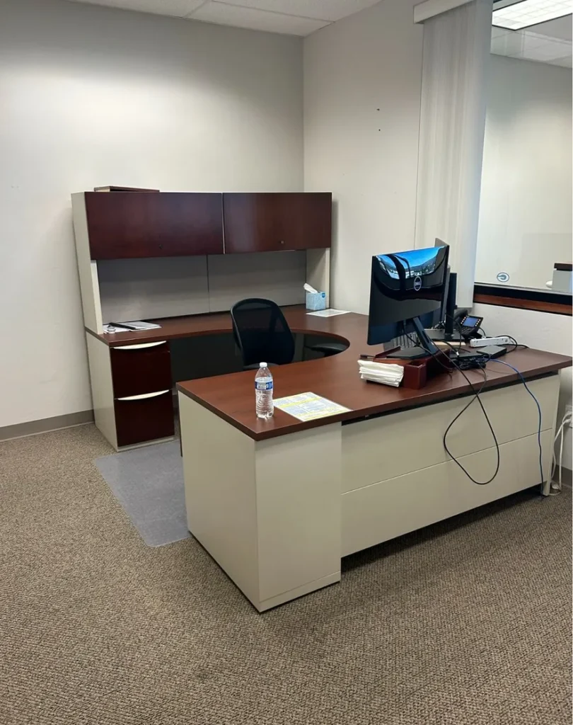 Dated case goods, no dedicated guest seating flow, no tackboard.