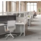 Modular cubicles with walnut wood panels, clear acrylic toppers, a white frame and sit-stand desks in a brick loft office